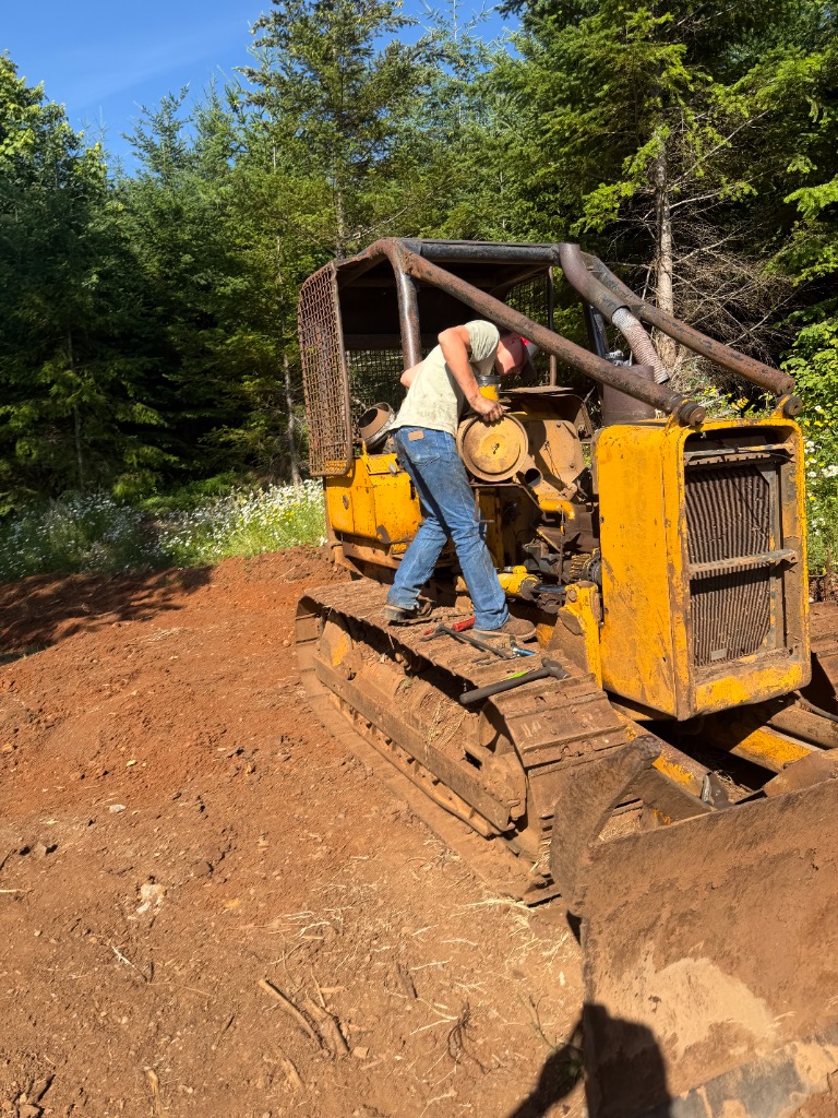JTF technician performing diesel engine overhaul on yellow crawler bulldozer on timber jobsite