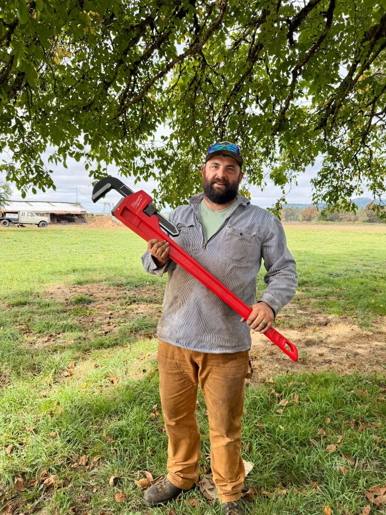JTF Mobile Repair technician with heavy 48-inch Milwaukee wrench in Oregon farm field